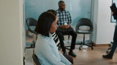 Çok ırklı bir grup insan CV kağıtlarını alıyor ve bekliyor.