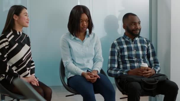 Office worker giving cv resumé to diverse group of applicants — Stock video