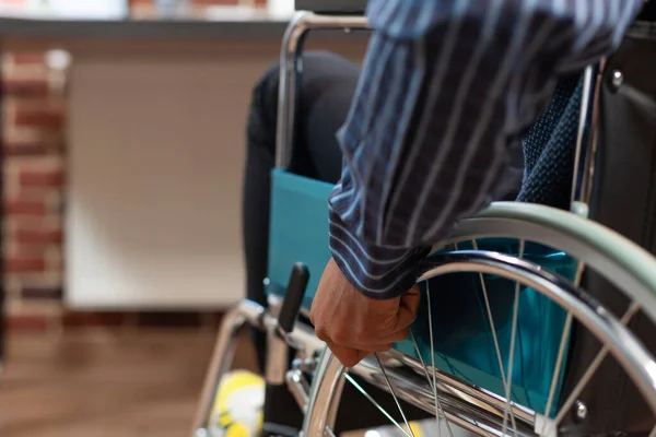 Concentre-se em startup empregado mão segurando aro de roda de cadeira de rodas para se deslocar — Fotografia de Stock