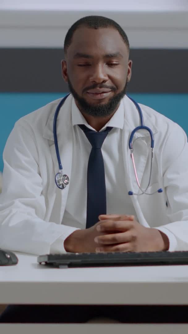Retrato del médico afroamericano sentado en el escritorio analizando informe diagnóstico de enfermedad — Vídeos de Stock