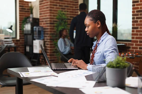 Довірлива афро-американська бізнес-жінка, яка аналізує проектну фінансову статистику. — стокове фото