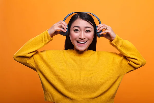 Mooie glimlachende hartelijke vrouw nemen van koptelefoon als ze ontmoet haar vriend. — Stockfoto