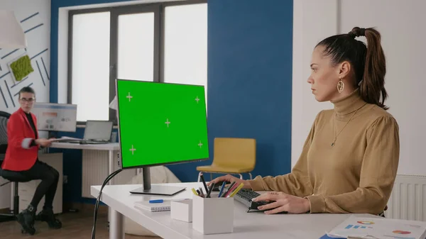 Бизнес-леди смотрит на зеленый экран компьютера — стоковое фото