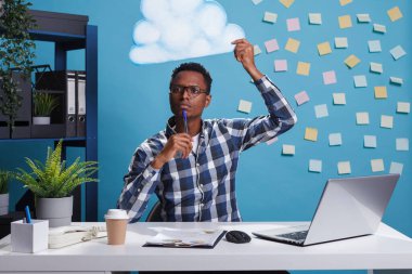 Düşünceli ve odaklı girişimci kafasının üstünde bulut kabarcığı ile doğru iş planlama hakkında düşünürken.