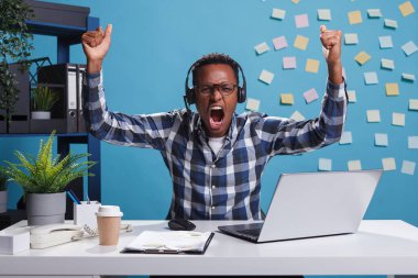 Müşteri destek operatörü başarılı iş gününü zaferle yumruklarını sıkarak kutluyor..