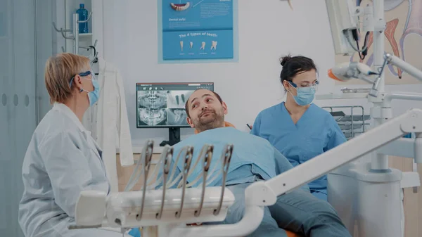 Stomatolog i pielęgniarka kończą procedurę leczenia doustnego z pacjentem — Zdjęcie stockowe