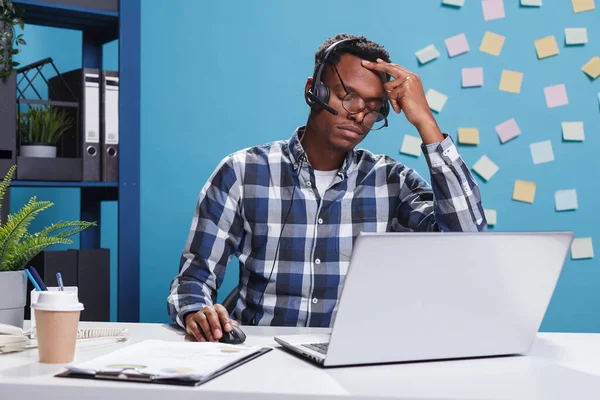 Verärgerter und müder Telemarketing-Berater mit schmerzhaftem Kopfschmerz — Stockfoto