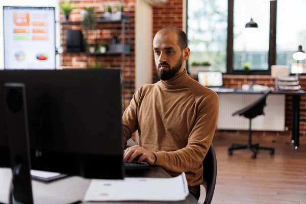 Empresario de empresa pensando en soluciones financieras mientras está sentado en el escritorio en el espacio de oficina — Foto de Stock