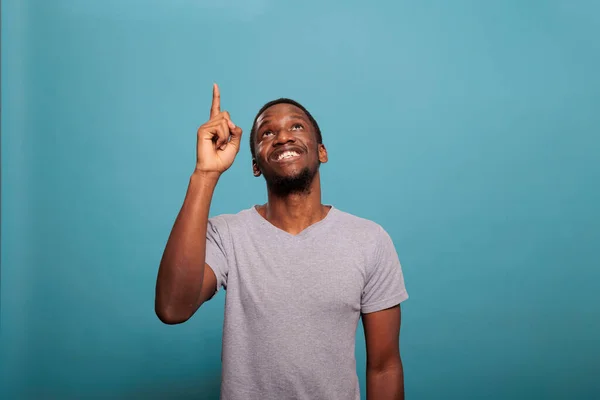 Retrato do homem afro-americano apontando para cima com o dedo indicador — Fotografia de Stock