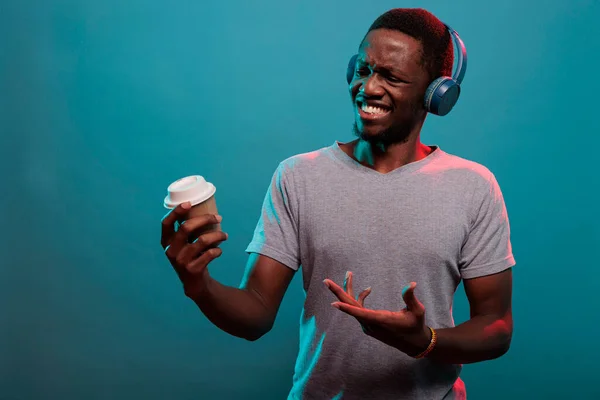 Ευτυχισμένος ενήλικας φορώντας ακουστικά για να ακούσετε μουσική mp3 και να έχουν ποτό — Φωτογραφία Αρχείου