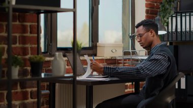 Dizüstü bilgisayardaki finansal istatistikleri analiz eden Afrikalı Amerikalı.