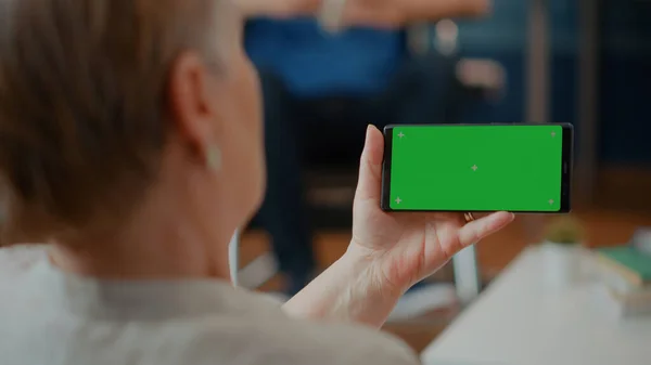 Smartphone adulto in pensione con schermo verde orizzontale — Foto Stock