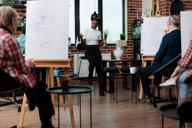 Sanat öğretmeni sanat öğrencilerine sanatsal becerilerini nasıl geliştireceklerini öğretiyor.