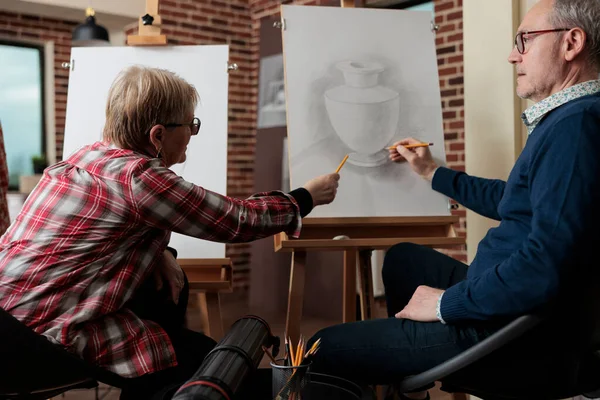 Ηλικιωμένος δάσκαλος που εξηγεί μάθημα εικονογράφησης στο μαθητή κατά τη διάρκεια μαθημάτων τέχνης — Φωτογραφία Αρχείου