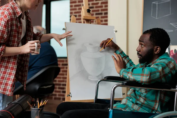 Pintor profesor mostrando técnica de dibujo a estudiante discapacitado —  Fotos de Stock