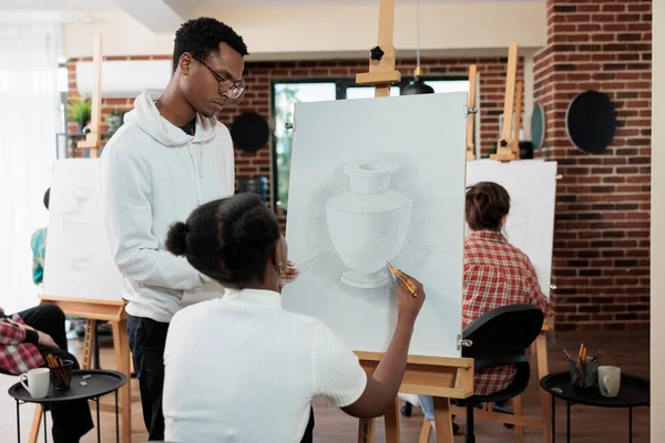Professor de pintura explicando a técnica de ilustração para o aluno — Fotografia de Stock