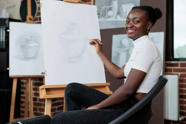 Портрет студента, який посміхається і малює ескіз на полотні під час творчого мистецького класу — стокове фото