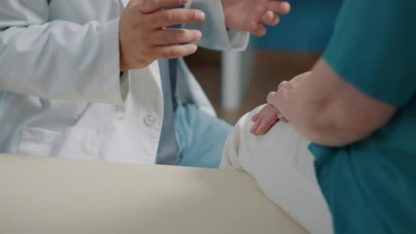 Männlicher Arzt tröstet Seniorin im Arztkabinett — Stockvideo