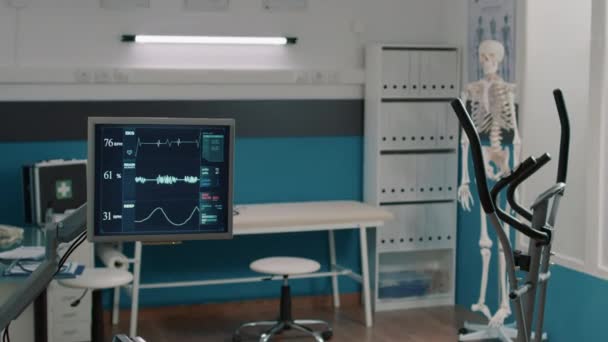 Oficina de rehabilitación con bicicleta fija y monitor de frecuencia cardíaca — Vídeo de stock