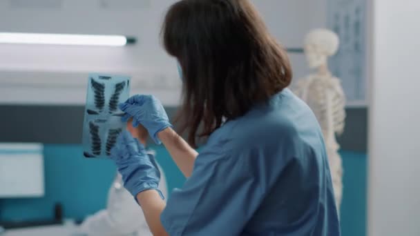 Eski hastaya röntgen taraması sonuçlarını kullanan tıbbi asistan — Stok video