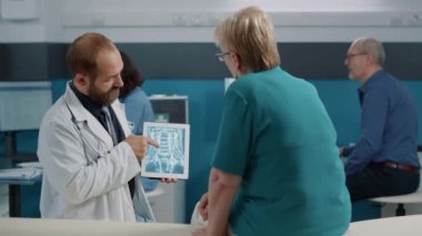 Doktor ve kıdemli hasta röntgen sonuçlarına bakıyor.