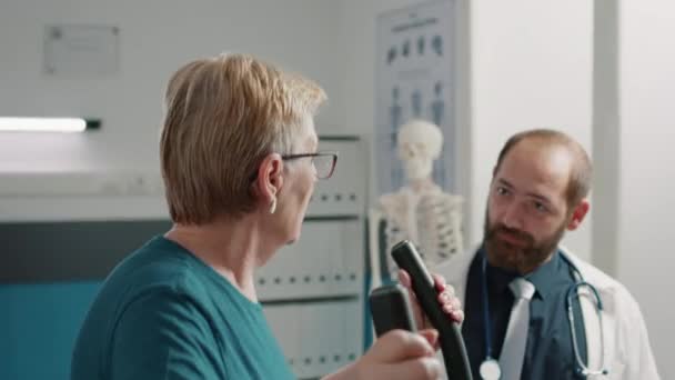 Patient âgé effectuant une procédure de récupération sur vélo stationnaire — Video