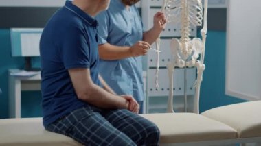 Osteopati uzmanı insan iskeleti üzerindeki omurilik sistemini açıklıyor.