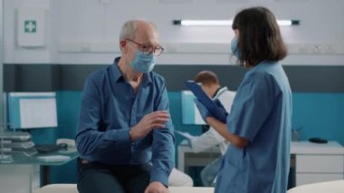 Konsültasyonda kontrol kağıtlarını imzalayan kıdemli adam.