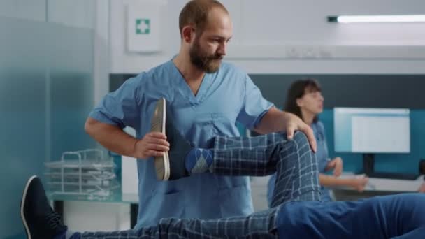 Specjalista medyczny podnoszący nogi do złamania kości i rozciągnięcia mięśni — Wideo stockowe