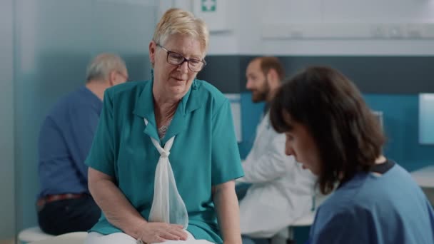 Oudere patiënt in gesprek met vrouwelijke verpleegster over herstel — Stockvideo