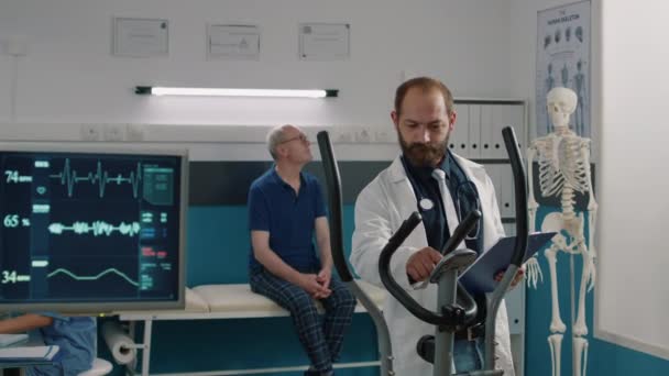 Retrato del médico que usa bicicleta fija para ayudar a los pacientes — Vídeo de stock