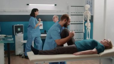 Fizyoterapist yaşlı bir hastaya fiziksel yaralanma konusunda yardım ediyor.