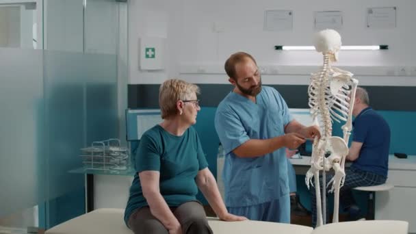 Osteopaat die de orthopedische diagnose op het menselijk skelet verklaart — Stockvideo