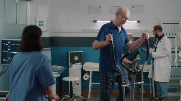 Portret starszego pacjenta korzystającego z roweru stacjonarnego do programu rehabilitacyjnego — Wideo stockowe