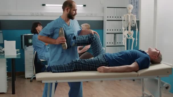 Osteopati uzmanı kaslarını esnetiyor ve bacak kemiklerini kırıyor. — Stok video