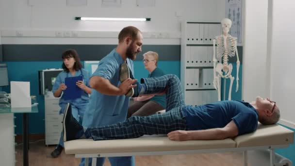 Терапевт за допомогою ніг підвищує вправи для розтягування м'язів і тріщин кісток — стокове відео