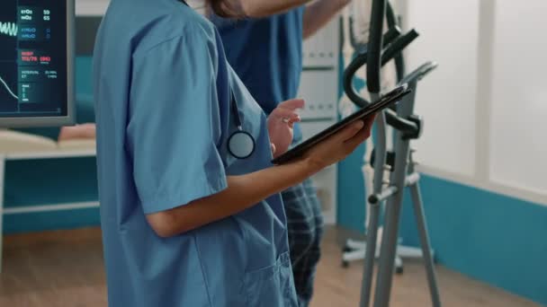 Health specialist in uniform using digital tablet to help senior patient — Stock Video