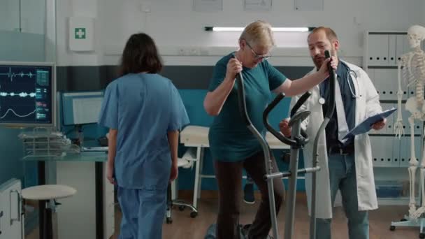 Patient âgé faisant de l'exercice musculaire sur vélo stationnaire — Video