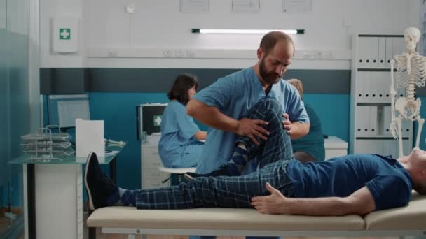 Manlig utövare som gör ben höja proceduren för att knäcka ben — Stockvideo
