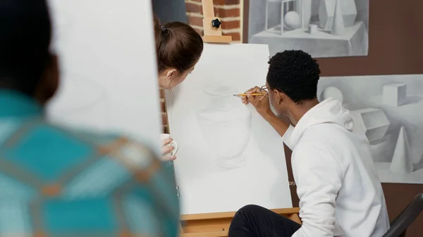 Junge Lehrerin spricht mit Schüler über Zeichnen — Stockfoto