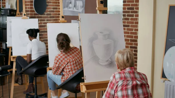 Étudiant aîné utilisant un crayon pour dessiner sur toile en classe d'art — Photo