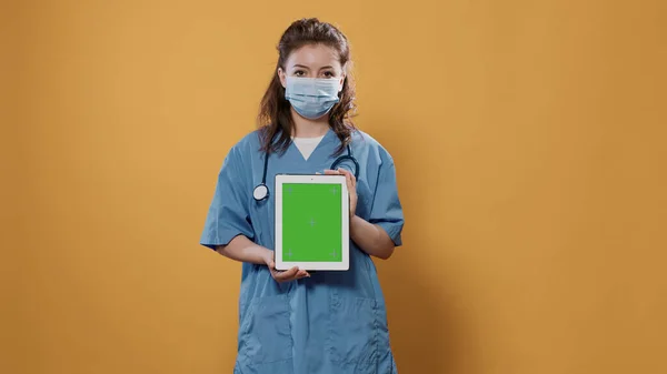 병원 복을 입은 녹색 화면이 달린 디지탈 태블릿을 들고 있는 확신있는 주검 의사 — 스톡 사진