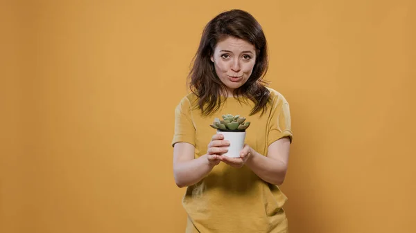 Porträt einer Frau im Gespräch über ihr Gartenhobby und die Pflege der sukkulenten Zimmerpflanze — Stockfoto