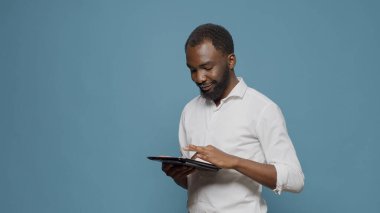 Stüdyoda dijital tablet üzerinde internet gezen şirket çalışanı