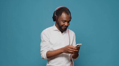 Modern yetişkin müzik dinlemek için kulaklık ve akıllı telefon kullanıyor.