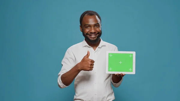 Szczęśliwy człowiek wskazując na cyfrowy tablet z poziomym zielonym ekranem — Zdjęcie stockowe