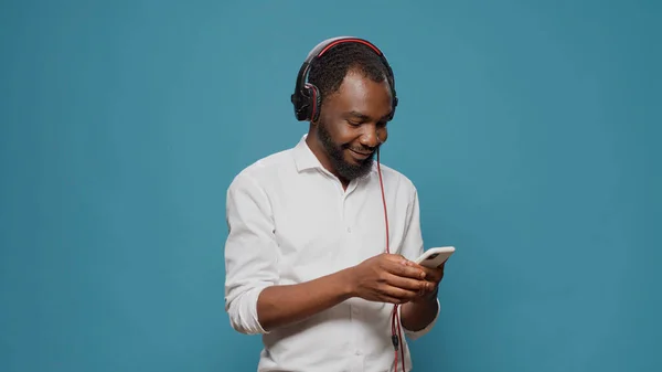 Moderne Erwachsene mit Headset und Smartphone, um Musik zu hören — Stockfoto