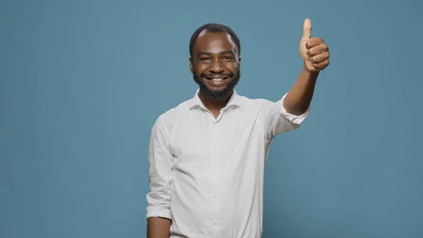 Африканский американец показывает большие пальцы перед камерой — стоковое фото