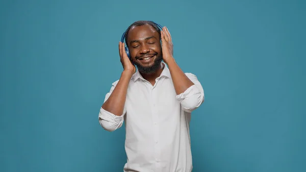 Adulto sonriente usando auriculares para escuchar música de radio mp3 —  Fotos de Stock