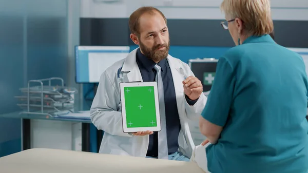 Médecin généraliste utilisant une tablette numérique avec écran vert — Photo